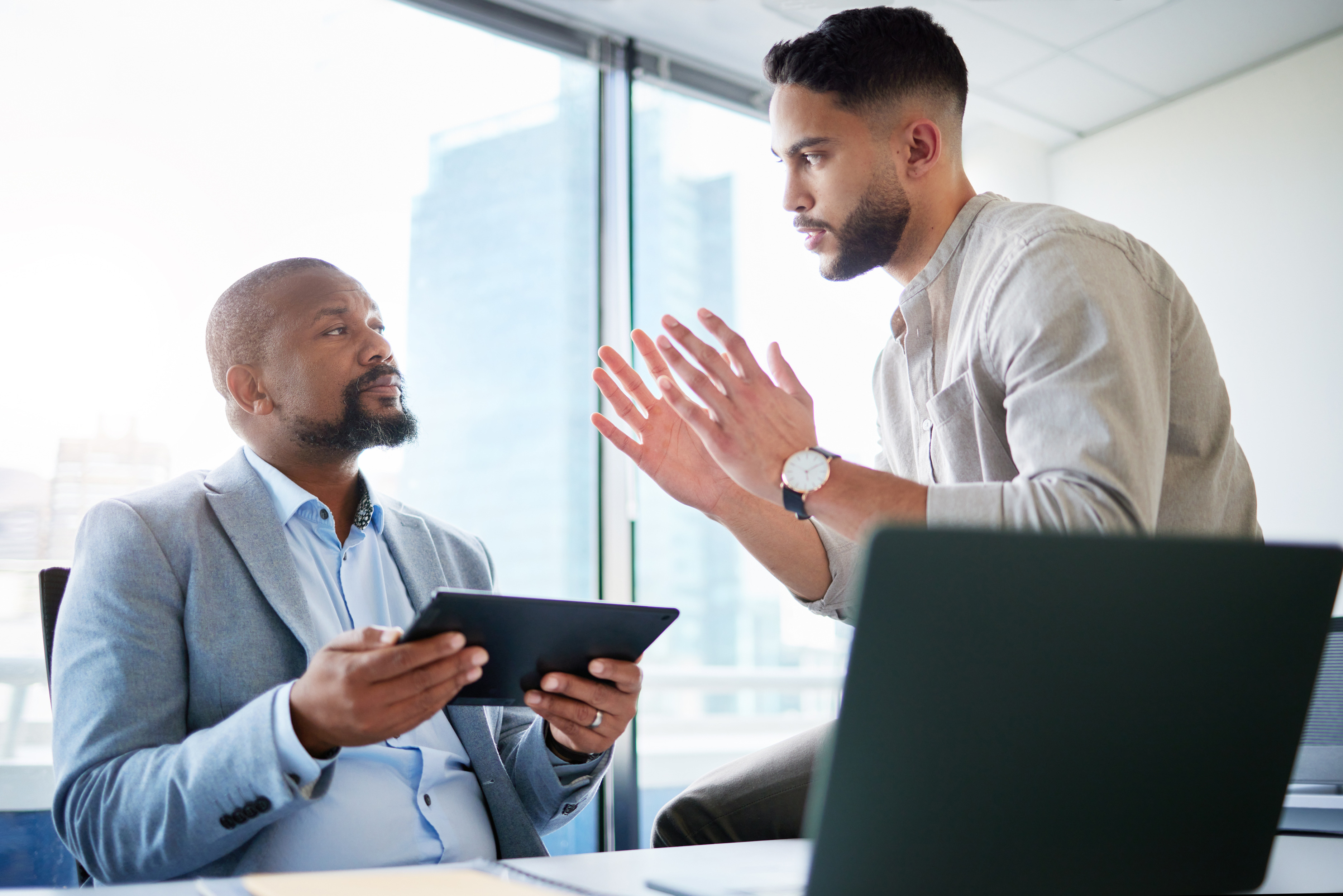 Equipe em reunião analisando proposta em tablet