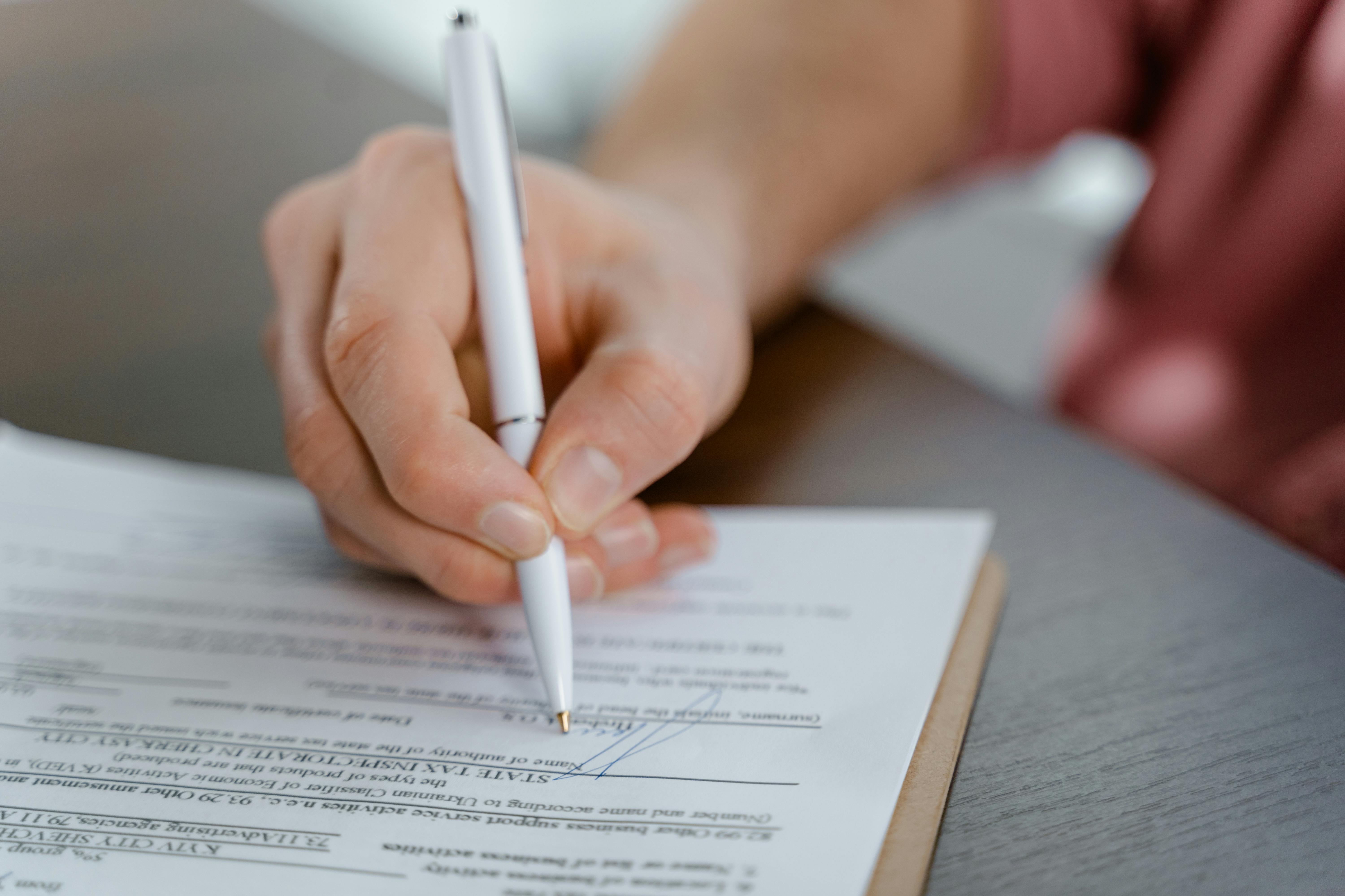 Profissional assinando contrato em mesa de escritório